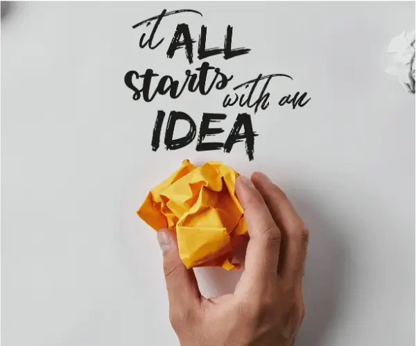 It all start with an idea written on grey background with man's hand holding yellow papper